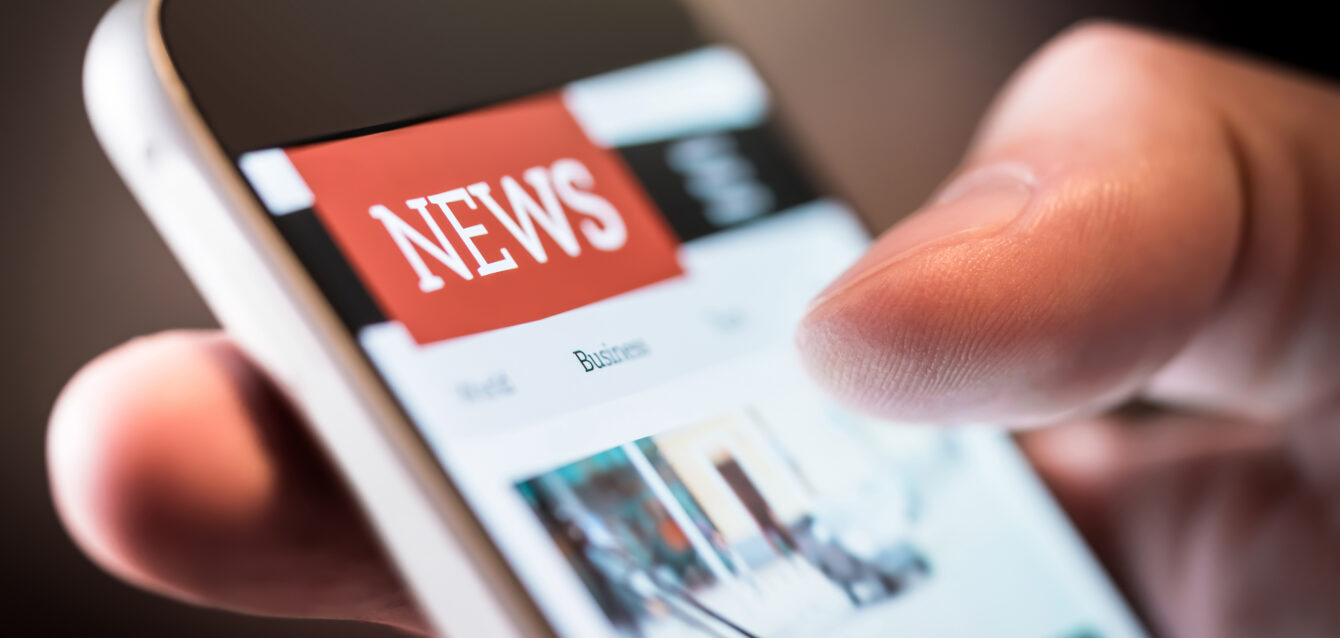 Online news in mobile phone. Close up of smartphone screen. Man